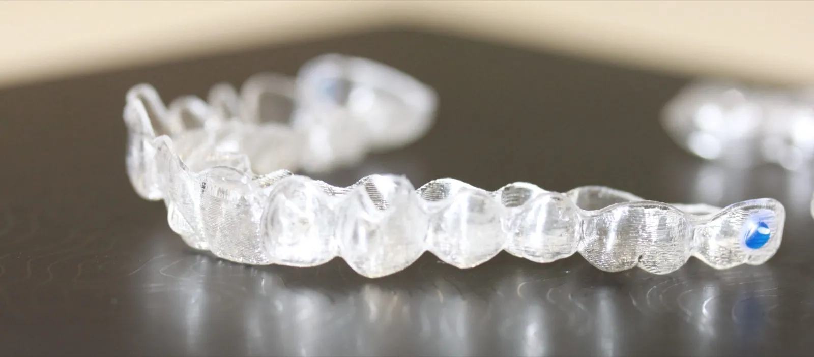 Alineador de ortodoncia invisible transparente sobre una superficie oscura