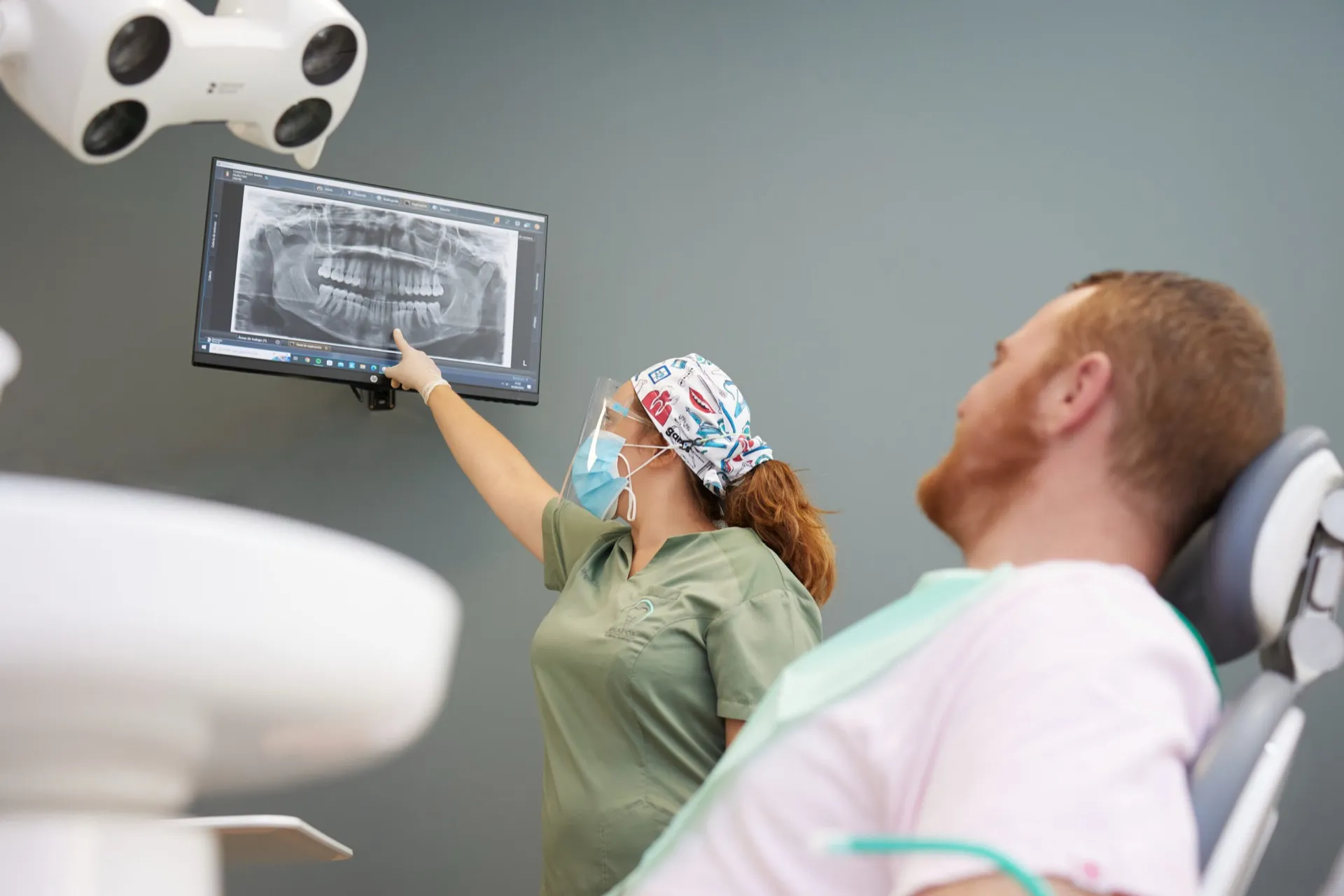 Profesional del Instituto Dental Campos revisando una radiografía dental con un paciente