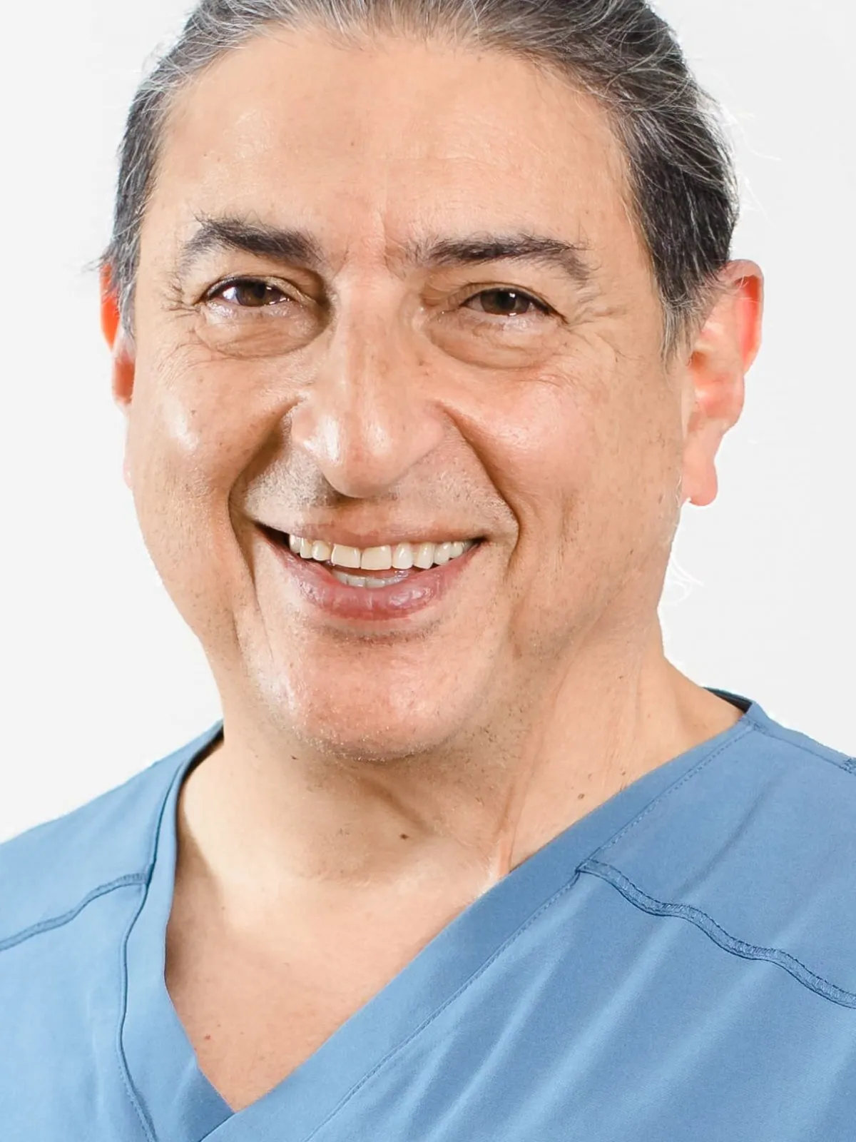 El Dr. Jorge Campos, director clínico del Instituto Dental Campos, sonriendo con uniforme sanitario