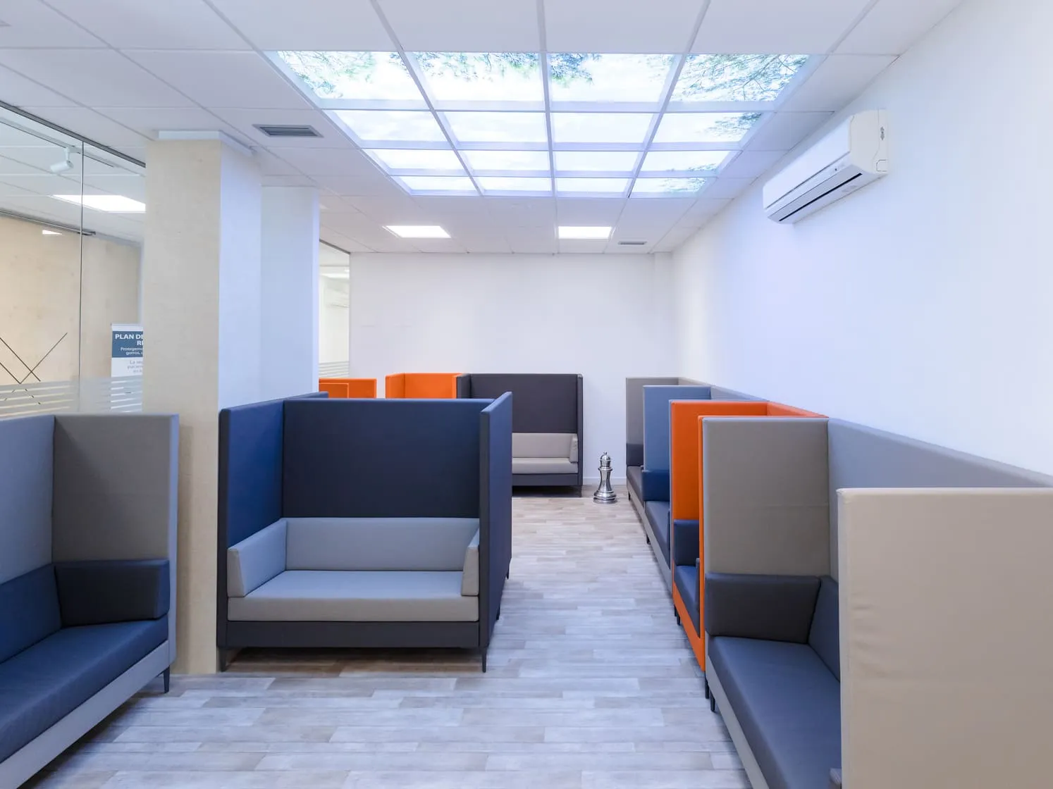 Sala de espera del Instituto Dental Campos en Vigo, con cabinas individuales y lucernario
